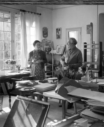 Marc Chagall and Valentina smiling at each other in a tidy studio filled with light.