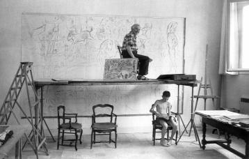 Marc Chagall sourit, installé sur un échaffaudage lui permettant de travailler sur une œuvre monumentale.