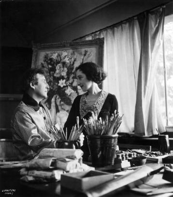 Marc and Bella Chagall looking at one another in front of the painting entitled Fiancés.