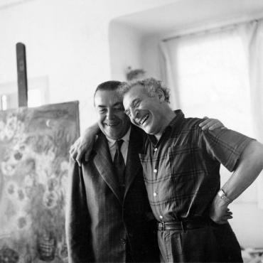 Marc Chagall et Tériade rient en se tenant par l'épaule.